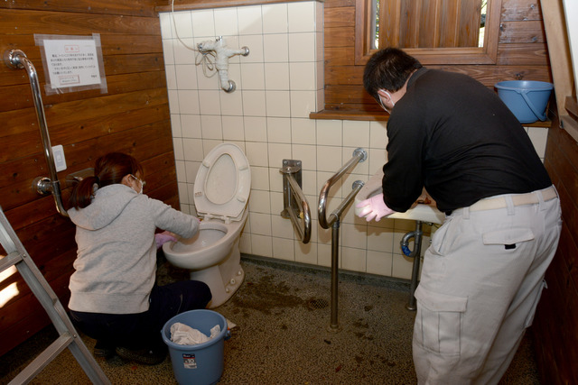 矢木羽湖の公衆トイレにてボランティア清掃活動の方がトイレの便器と蛇口の清掃をしている写真